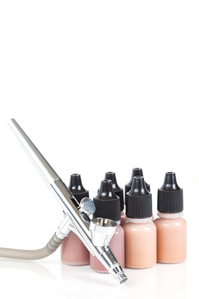 airbrush and bottles of liquid foundation
